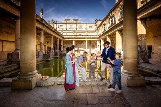 Roman Baths in Bath, showing photo of a family with a lady dressed as a Roman